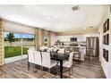 Bright dining area with sliding glass doors and an open floorplan connected to the modern kitchen at 37061 Sagemoor Dr, Zephyrhills, FL 33541