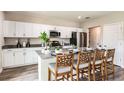 Modern kitchen with white cabinets, stainless steel appliances, and a spacious island with bar seating at 37061 Sagemoor Dr, Zephyrhills, FL 33541