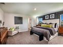 A serene main bedroom boasts a large bed, stylish decor, and an ensuite bathroom at 37061 Sagemoor Dr, Zephyrhills, FL 33541