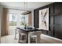 Dining room with a dark accent wall, stylish lighting, and a large window with natural light at 37128 Sagemoor Dr, Zephyrhills, FL 33541