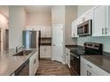 Bright kitchen with stainless steel appliances, stone countertops, and white cabinets at 37171 Sagemoor Dr, Zephyrhills, FL 33541