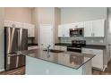 Modern kitchen with white cabinets, stainless steel appliances, island and neutral countertops at 37171 Sagemoor Dr, Zephyrhills, FL 33541