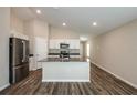 Open-concept kitchen featuring stainless steel appliances, dark countertops and hardwood floors at 37171 Sagemoor Dr, Zephyrhills, FL 33541