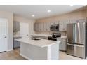 Modern kitchen with gray cabinets, stainless steel appliances, and center island at 37198 Sagemoor Dr, Zephyrhills, FL 33541