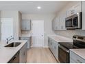 Bright kitchen featuring gray cabinets, stainless steel appliances, and ample countertop space at 37198 Sagemoor Dr, Zephyrhills, FL 33541