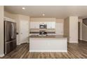 Bright kitchen boasts an island with sink and white cabinets at 37222 Sagemoor Dr, Zephyrhills, FL 33541
