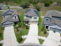 Aerial view of a two-story home with solar panels, surrounded by well-maintained lawns at 4513 Eternal Prince Dr, Sun City Center, FL 33573