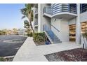 Close-up view of the condo's exterior highlighting the well-manicured landscaping and blue stair railings at 4823 Ebbtide Ln # 304, Port Richey, FL 34668