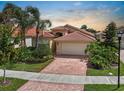 Beautiful single Gathering home with a tile roof, two-car garage and a red brick driveway at 4917 Sandy Brook Crk, Wimauma, FL 33598