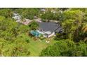 Aerial view of a home featuring a screened pool, fire pit area, and a spacious, well-maintained backyard at 50 Pine Lake Dr, Oldsmar, FL 34677