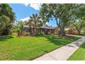 Well-maintained home with beautiful landscaping, stone accents, screened in porch, and a lush lawn at 50 Pine Lake Dr, Oldsmar, FL 34677