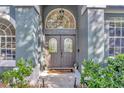 Inviting entryway featuring a double door with decorative windows and manicured landscaping at 5212 Twin Creeks Dr, Valrico, FL 33596