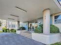 Building entrance with pillars, exterior lighting, tile accents, and manicured landscaping at 55 Harbor View Ln # 108, Belleair Bluffs, FL 33770