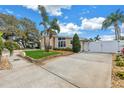 Charming home exterior featuring well-maintained landscaping, a spacious driveway, and a secure gated entrance at 6630 Gulfport S Blvd, South Pasadena, FL 33707