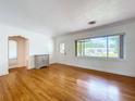 Spacious living room featuring hardwood floors and a large window for natural light at 6920 Bougainvilla S Ave, St Petersburg, FL 33707