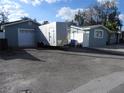 Exterior view of a home with a detached garage and a trailer parked in front, showcasing ample parking space at 8822 Rocky Creek Dr, Tampa, FL 33615