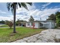 A well-maintained house front exterior with a neat lawn and mature palm tree at 10275 117Th Dr, Largo, FL 33773