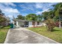Exterior shot showcasing home with concrete driveway, carport and tidy front lawn at 10275 117Th Dr, Largo, FL 33773