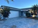A single-story home with an attached garage, landscaping, and blue exterior paint at 11096 117Th Way, Seminole, FL 33778