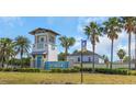 Lucaya Lake Club entrance featuring a decorative tower, clear blue signage, and mature palm trees at 11142 Spring Point Cir, Riverview, FL 33579