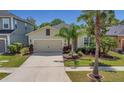 Inviting single-Gathering home featuring a neutral exterior, attached garage, and lush landscaping at 11142 Spring Point Cir, Riverview, FL 33579