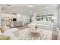 Bright, open-concept living room featuring modern decor and a seamless transition to the stylish kitchen at 11447 Shoreline Trl, Parrish, FL 34219