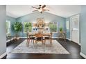 A dining room features blue walls, a ceiling fan, a table with four chairs and a decorative painting above a sideboard at 130 41St Ne Ave, St Petersburg, FL 33703