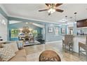 Open-concept living room features tile flooring, recessed lights, ceiling fan and transitions to kitchen bar seating at 130 41St Ne Ave, St Petersburg, FL 33703