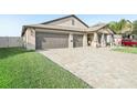 Charming single-story home featuring a three-car garage, and a neatly manicured front lawn at 14413 Seattle Slew Ln, Ruskin, FL 33573