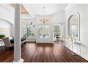 Bright foyer featuring high ceilings, hardwood floors, an elegant chandelier, and large windows with white trim at 15045 Wind Whisper Dr, Odessa, FL 33556