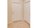 Bright entryway with tile floors showcasing the front door and a hallway door at 15410 Quail Woods Pl, Ruskin, FL 33573