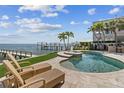 A backyard pool and outdoor lounge area with comfortable seating and a stunning waterfront view. A great space for relaxing at 1737 Brightwaters Ne Blvd, St Petersburg, FL 33704