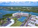 Aerial view of waterfront condo community with tennis courts and ample parking at 19451 Gulf Blvd # 211, Indian Shores, FL 33785