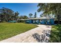 Quaint blue home with driveway and green lawn, with room to park a boat at 1965 Allard Dr, Clearwater, FL 33763