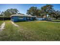 Charming blue home with big lawn, great for enjoying outdoor activities and entertaining at 1965 Allard Dr, Clearwater, FL 33763