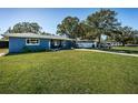 Lawn with blue house and long driveway, ideal for parking multiple vehicles, boats, or RVs at 1965 Allard Dr, Clearwater, FL 33763