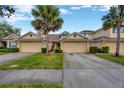 Townhouse exterior features a large driveway, well-maintained landscaping, and a welcoming facade at 20305 Oak Key Ct, Tampa, FL 33647
