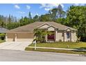 Charming single-story home featuring well-maintained landscaping and a welcoming three-car garage at 26249 Sword Dancer Dr, Wesley Chapel, FL 33544