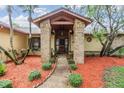 Inviting front entrance featuring brick pillars, well-maintained landscaping, and a charming wooden front door at 2664 Frisco Dr, Clearwater, FL 33761