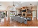Bright living room featuring hardwood floors, a stone fireplace, a ceiling fan, and access to the pool area at 2664 Frisco Dr, Clearwater, FL 33761