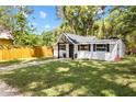 Quaint home displaying a manicured lawn, fresh landscaping, and a natural fence at 37401 Magnolia Ave, Dade City, FL 33523