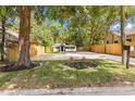 A charming home framed by mature trees, a well-maintained lawn and a fenced yard at 37401 Magnolia Ave, Dade City, FL 33523