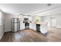 Open kitchen featuring stainless steel appliances, white cabinets, and wood-look flooring at 37401 Magnolia Ave, Dade City, FL 33523
