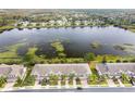 Stunning aerial view of townhomes near a serene lake and lush surroundings at 3844 Silverlake Way, Wesley Chapel, FL 33544