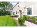 Charming home entrance featuring lush landscaping, stone accents, and a decorative front door at 3844 Silverlake Way, Wesley Chapel, FL 33544