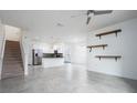 Open-concept living area featuring a modern kitchen with stainless steel appliances and staircase at 3844 Silverlake Way, Wesley Chapel, FL 33544