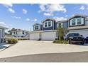 Exterior view of blue townhomes with white garage doors and a black Toyota SUV parked in the driveway at 414 Finn Way # 4, Dunedin, FL 34698