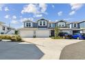 Exterior shot of blue townhomes with a two car garage, black Toyota, and blue hatchback parked in the driveway at 414 Finn Way # 4, Dunedin, FL 34698