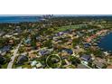 Aerial view showcases the neighborhood with mature trees, a golf course, and a distant city skyline at 459 Bayview Ne Dr, St Petersburg, FL 33704