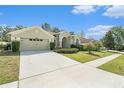 Attractive home featuring a spacious driveway, two-car garage, and beautifully maintained landscaping at 4656 Copper Hill Dr, Spring Hill, FL 34609